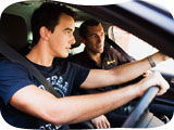 Image of a young man in a car being taught to drive
