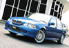Photo of a blue company car outside an office