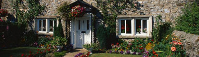 Get a quote for AA Holiday Home Insurance (image: house with a blue door surrounded by flowers Holiday Home Insurance