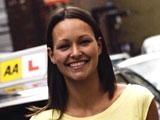 Image of a happy AA learner in front of her tuition car