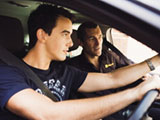 Image of a young man in a car being taught to drive