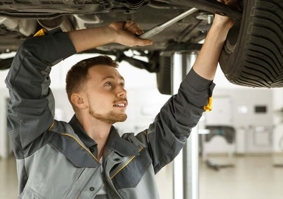 A mechanic fixes a vehicle's chassis Mechanic in garage fixing vehicle chassis