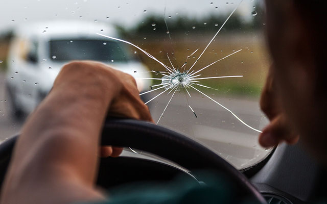 Windscreen insurance -  a damaged car windscreen with a crack