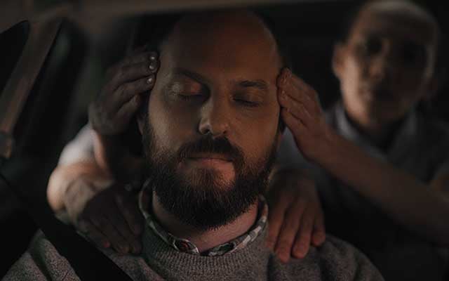 A tired driver is given a temple massage