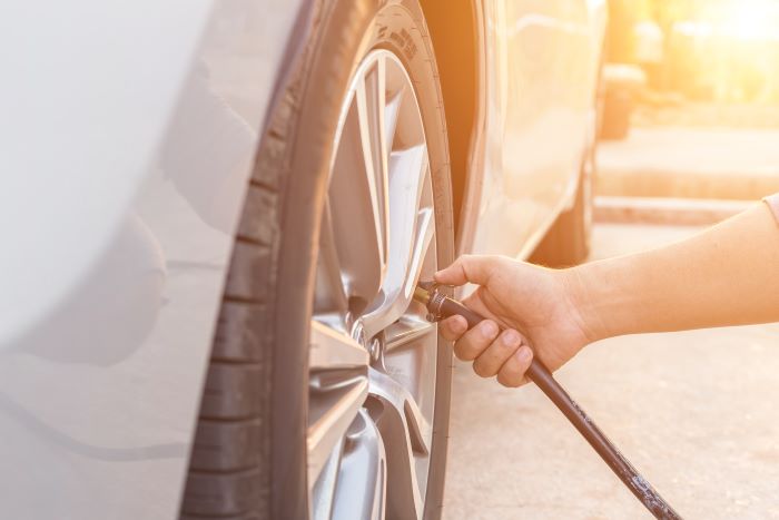 A person filling a car tyre with air.