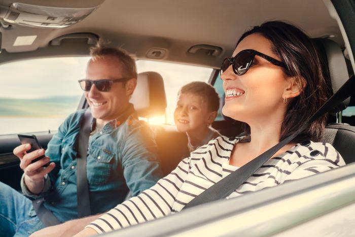 A happy family with mother, father and son enjoying a road trip together.