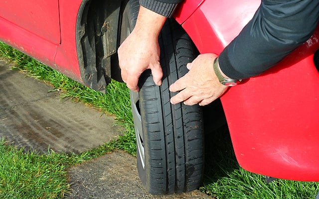 cehcking tread on car tyre