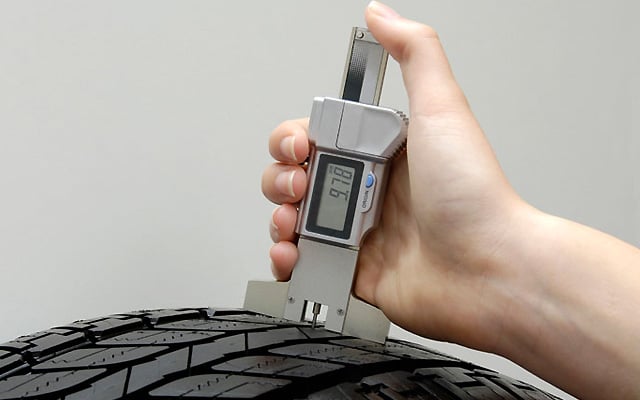 checking tyre with tread guage