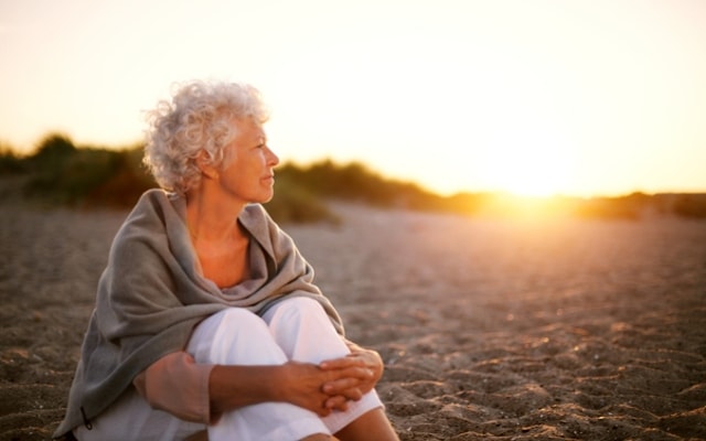 older woman enjoying a sunset on holiday