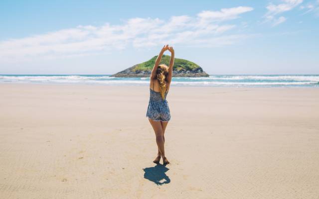 healthy woman stretching her muscles on the beach