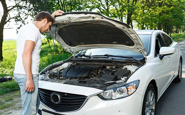 Man looking under car bonnet