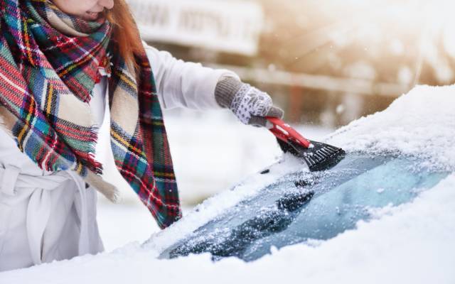 Clearing snow off car windscreen