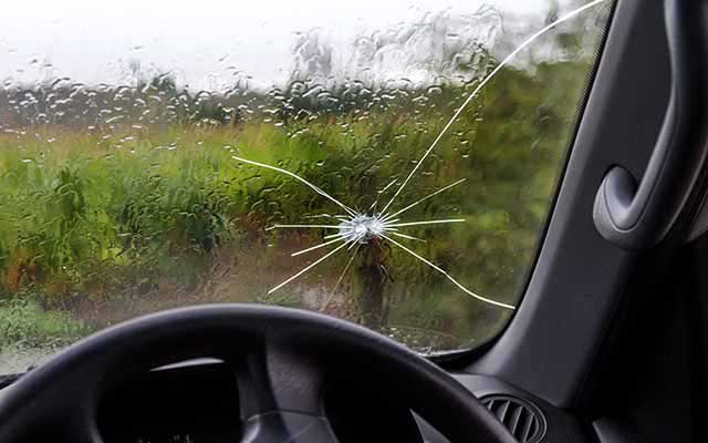 Car windscreen with crack above steering wheel