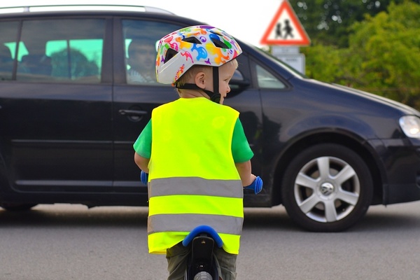 Young child on a bike with a car in front of him