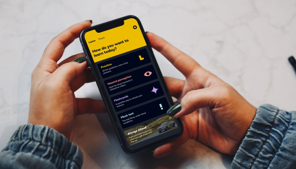 Theory app A person holding a smart phone using a driving theory test revision app