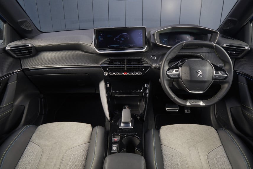 An image of the interior of a Peugeot e-208 taken from the backseat facing forward
