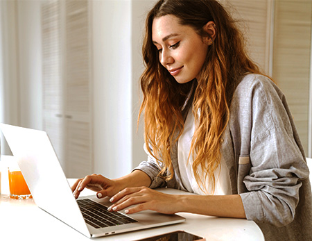 A woman types on her laptop.