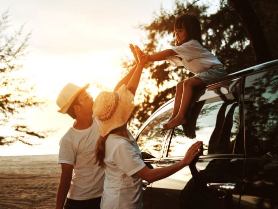 Family by a car near a sunset
