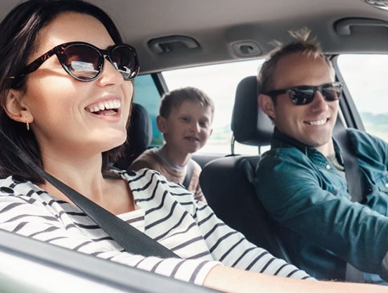 Happy young family in car A young family smiles in their car