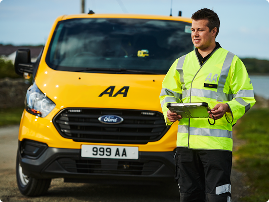 An AA patrol stands in front of his van, holding a clipboard.