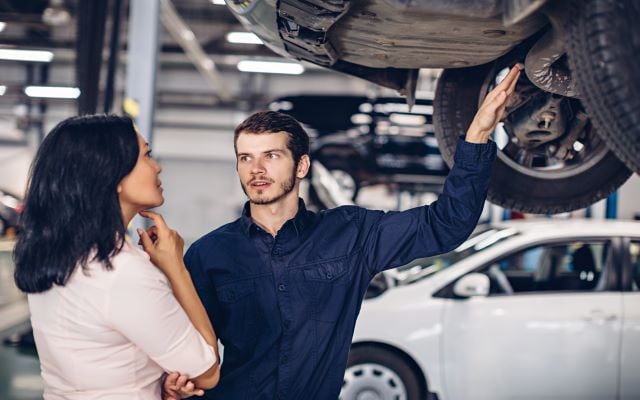 Mechanic showing a customer an issue with her vehicle